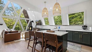 A modern kitchen with a large island, dark cabinets, and pendant lighting. - Sky-High A Frame Retreat Hottub & EV charging (Beech Mountain)