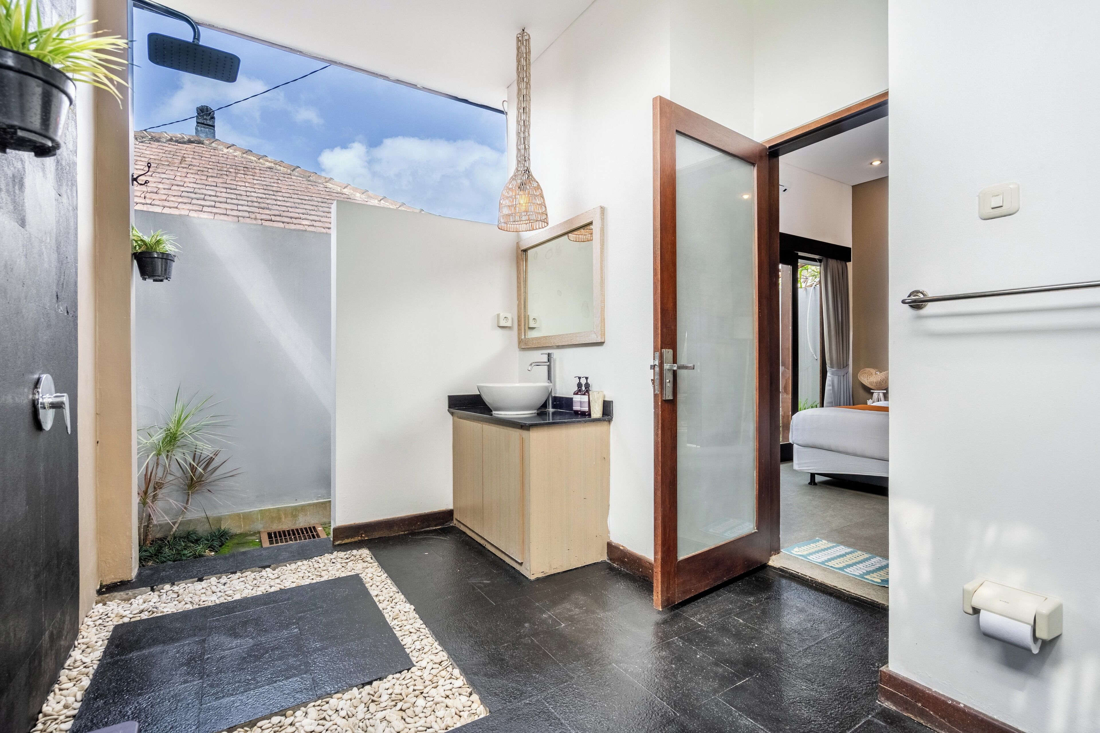 A modern bathroom with a large mirror, a sink, and a shower area.