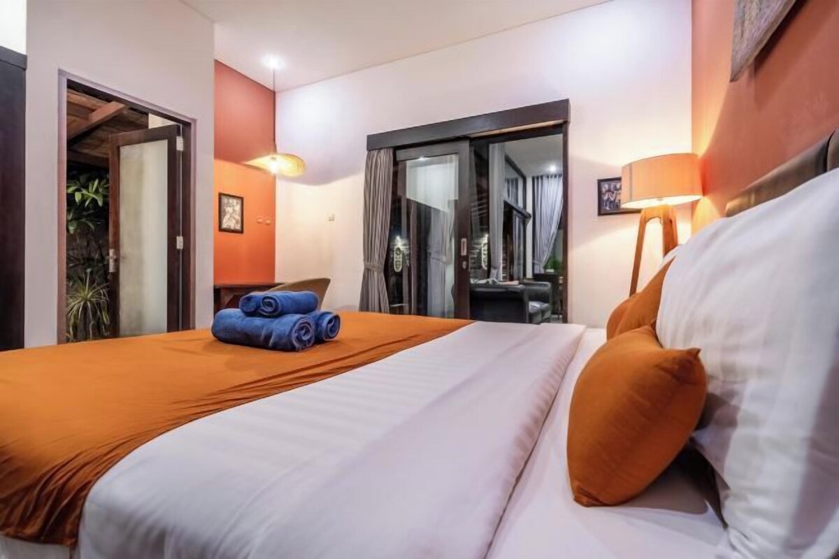 A hotel room with a bed, a desk, and a chair.