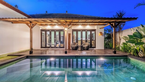 A modern pool area with a covered seating area and glass doors leading to the interior. - 888 Residences - Complex of Private Villas with Pools (Ubud)