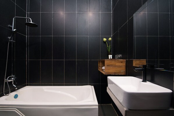 A modern bathroom with a bathtub, a shower, and a sink.