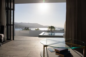 A modern living room with a glass table, a view of the sea, and a pool. - SARAH RESORT VILLA UMI (Motobu)
