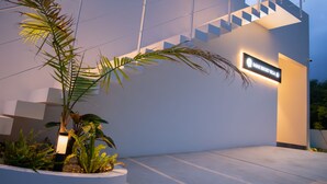 Een modern gebouw met een trap en een bord met de tekst 'Sahara Resort Villa'.