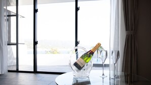 Een glazen tafel met een fles champagne en twee glazen erop.