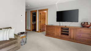 A living room with a sofa, a TV, and a wooden cabinet.