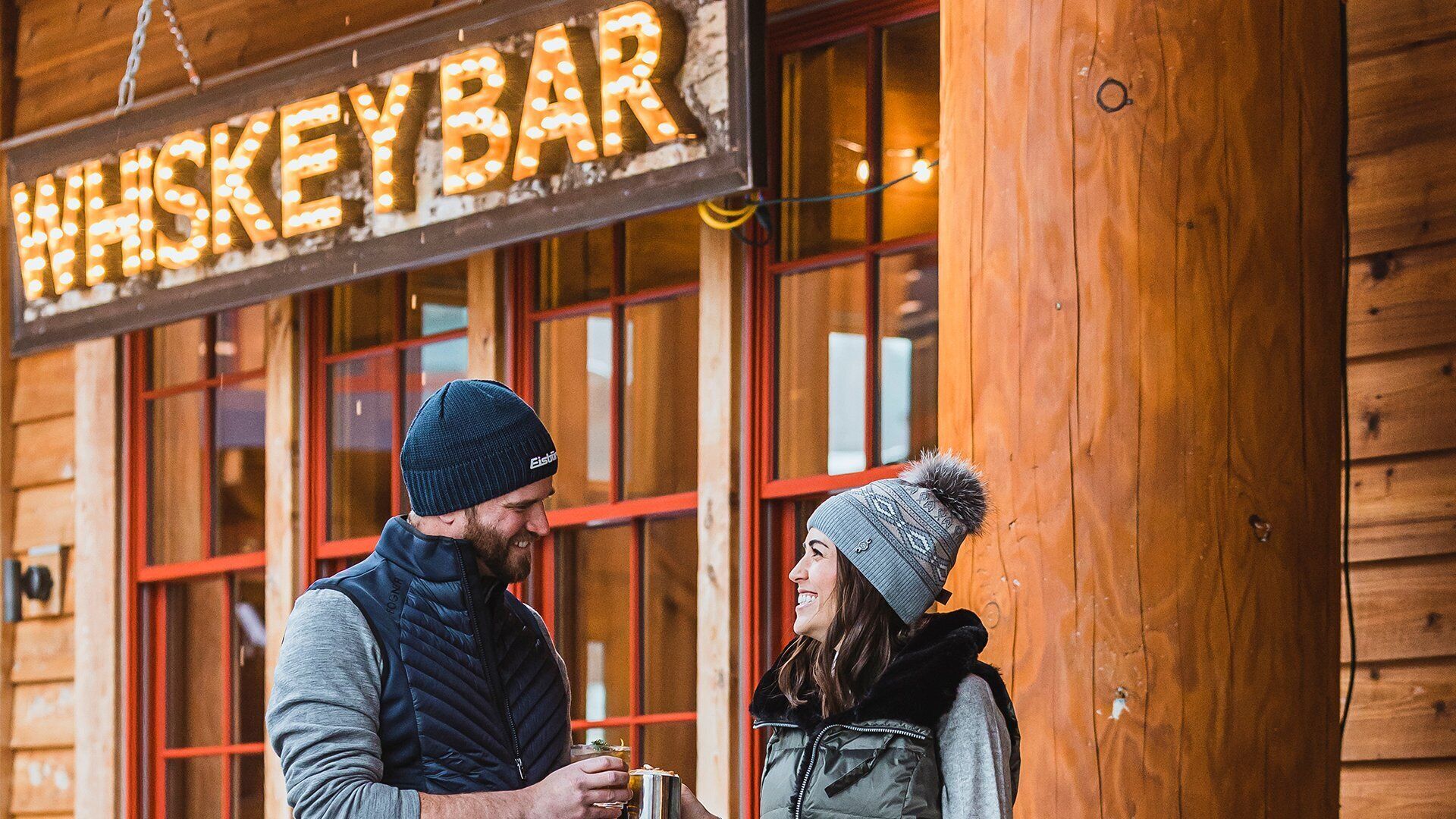 A wooden building with a sign reading "WHISKEY BAR".