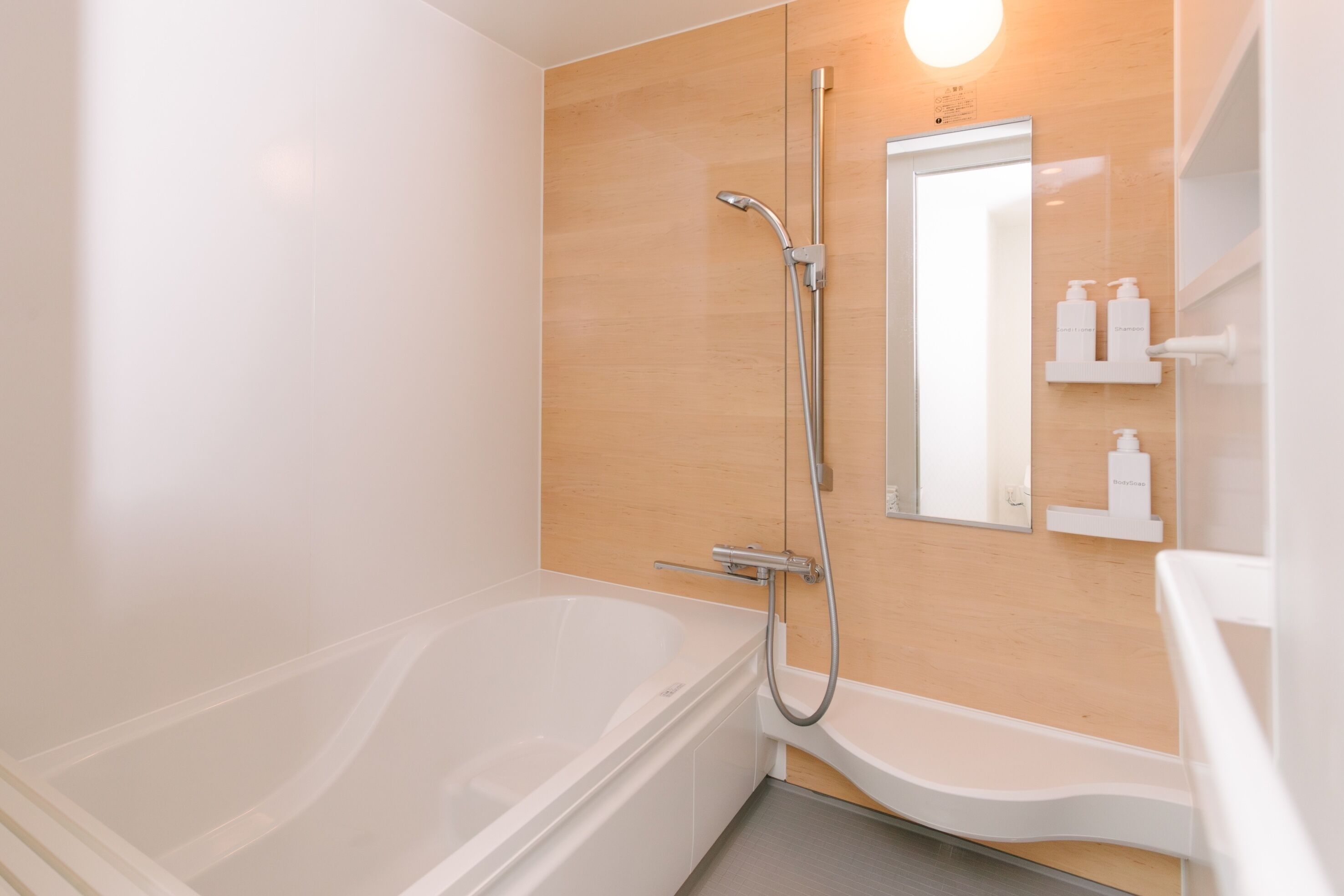 A modern bathroom with a bathtub, a shower, a sink, and a mirror.