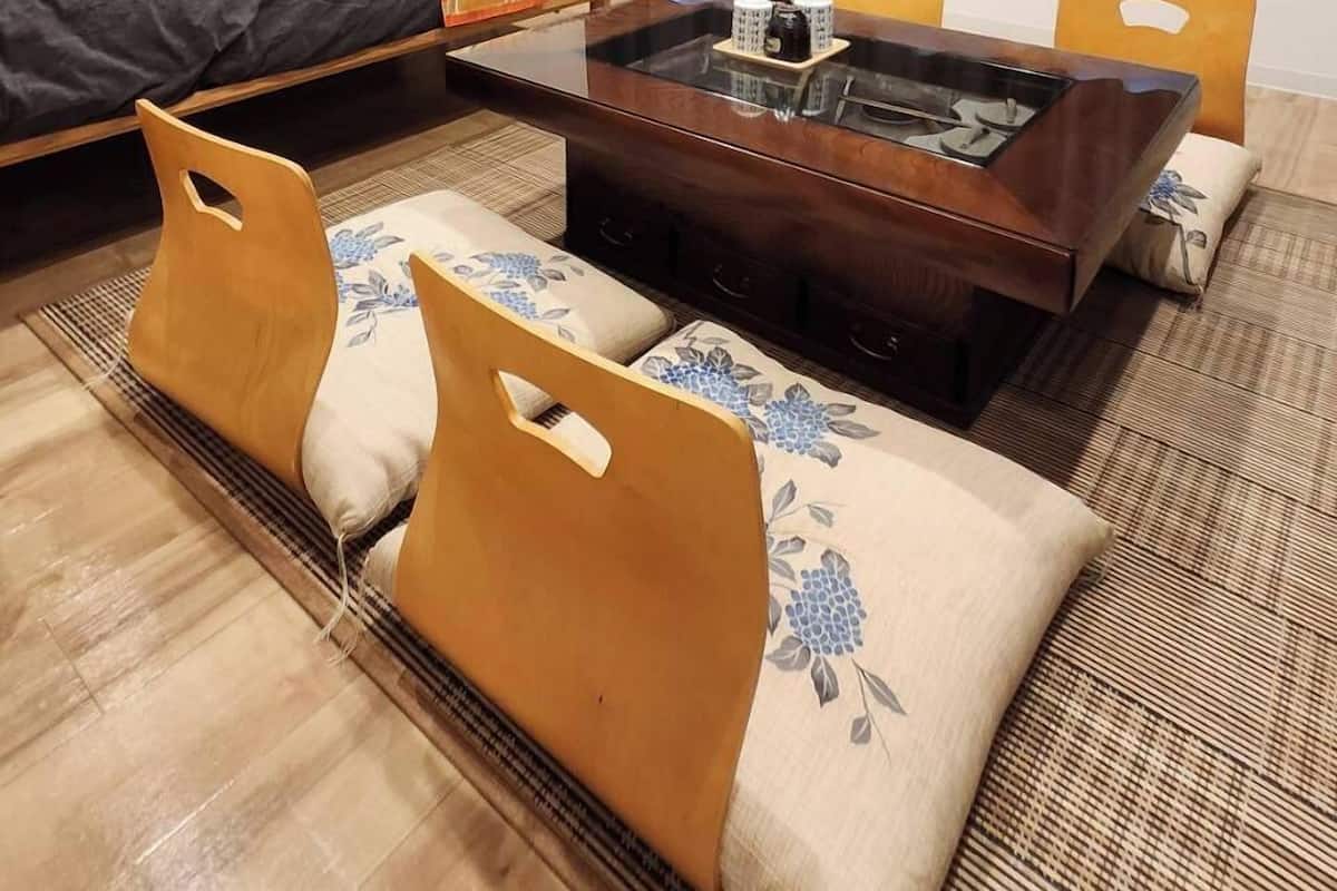 Une chambre d’hôtel moderne équipée d’un lit, d’une table à manger, de chaises, d’un canapé, d’un petit bureau et d’une fenêtre avec des rideaux.