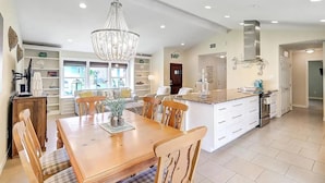 Una cocina amplia con una isla grande, una mesa de comedor de madera y sillas.