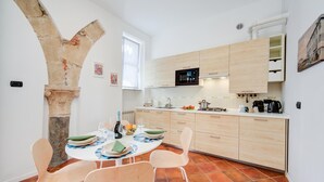 Una cocina moderna con arco de piedra, armarios de madera y piso de baldosas.