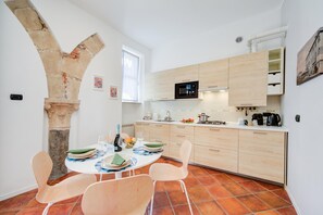 A modern kitchen with a stone arch, wooden cabinets, and a tiled floor. - Il Nido Del Cigno, Arona Lakefront Apartment with Terrace and A/C, Arona, Italy (Arona)