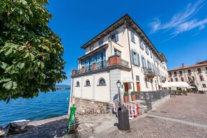 A waterfront building with a balcony, a stone wall, and a clear view of the water.