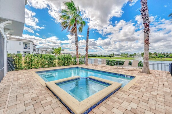 A rectangular swimming pool with a tiled edge, surrounded by a brick patio. - Golden View | 5 BR, Themed Rooms, Game Room, West-Facing Pool (Kissimmee)
