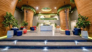 A modern lobby with a reception desk, seating area, and steps leading to an upper level. - HOMA Cherngtalay (Choeng Thale)