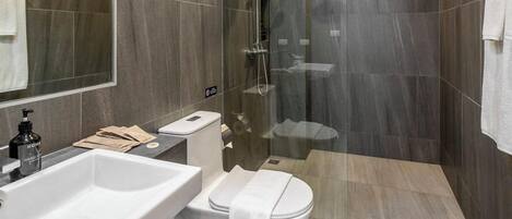 A modern bathroom with a white sink, toilet, and shower.