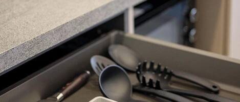 A kitchen drawer with utensils and cookware.