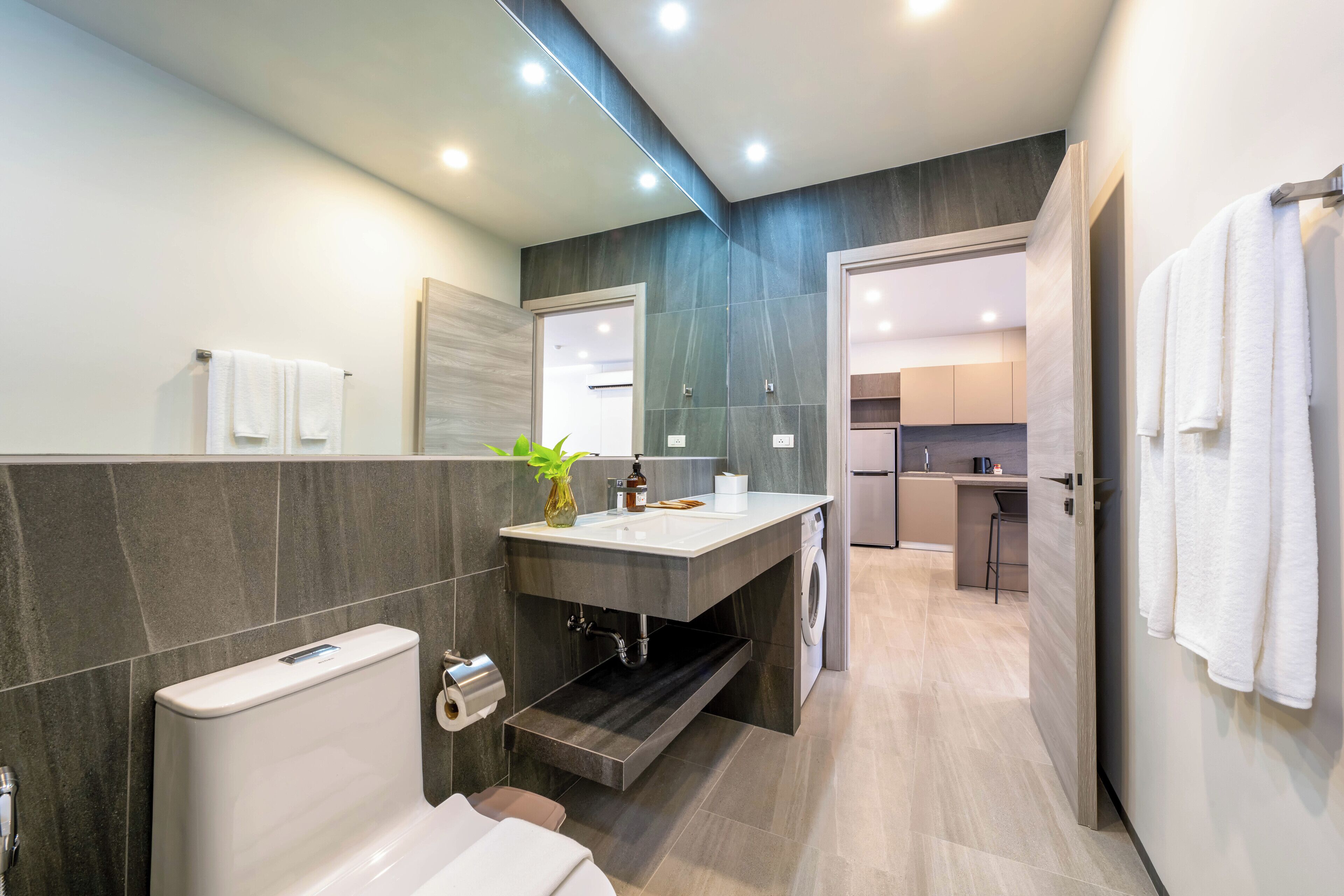 Une salle de bain moderne équipée de toilettes, d’un lavabo et d’un espace douche.