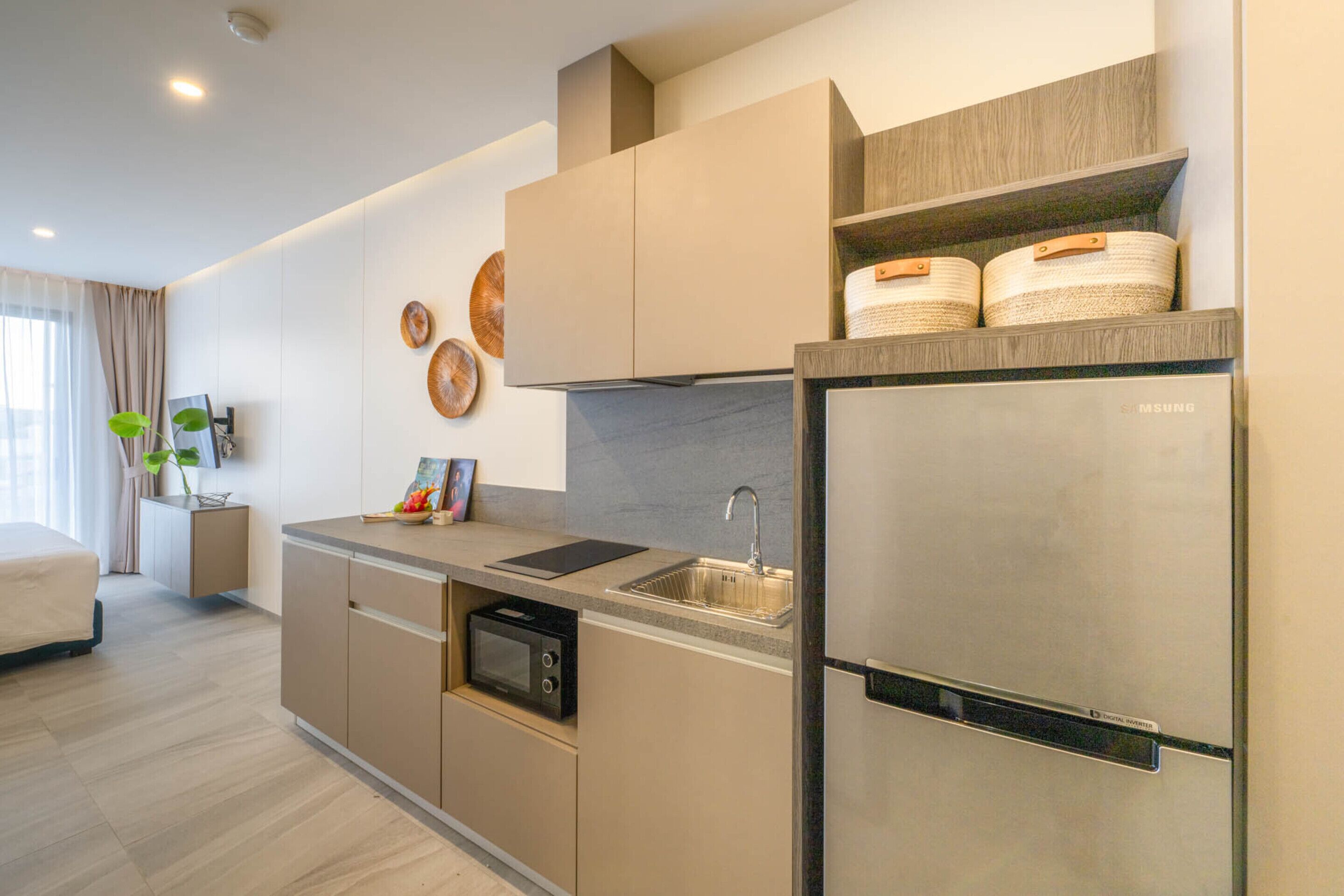 A modern kitchen with a built-in microwave, stainless steel sink, and a Samsung refrigerator.