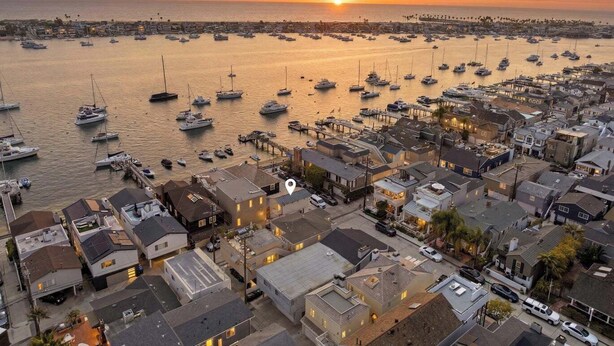 Un pueblo costero con numerosos barcos amarrados en un puerto deportivo, rodeado de edificios residenciales.