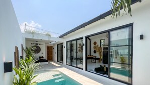 A modern house with a swimming pool, large glass doors, and a minimalist interior. - KAKAO Villas Kedungu (Tabanan)