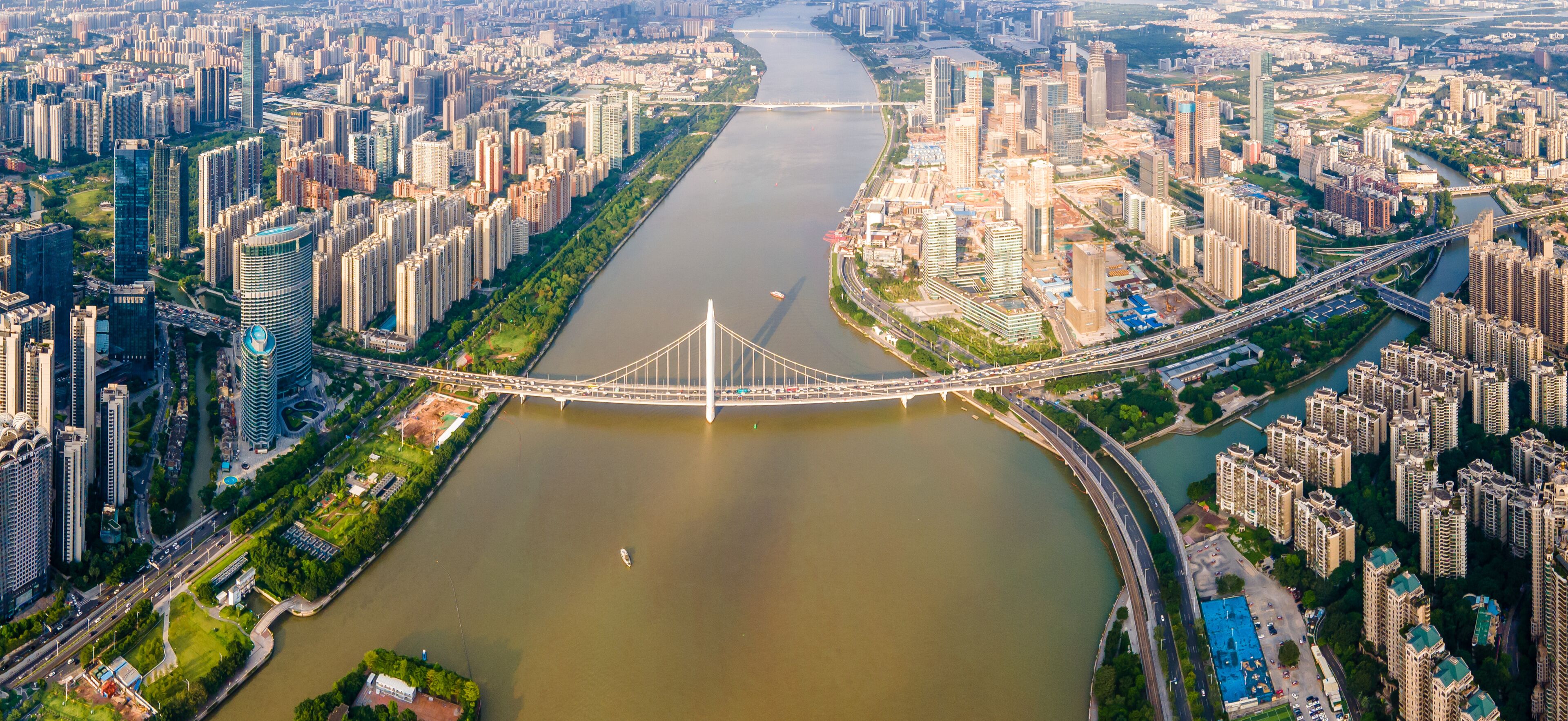 A high-rise building with a modern design, surrounded by a river and a bridge.