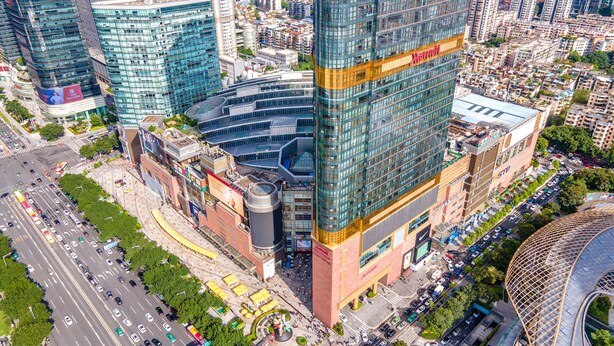 Un hotel de gran altura con un llamativo letrero de Marriott, rodeado de edificios urbanos y una calle concurrida.