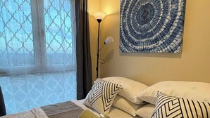 Una habitación de hotel con una cama, almohadas, una lámpara y un cuadro en la pared.