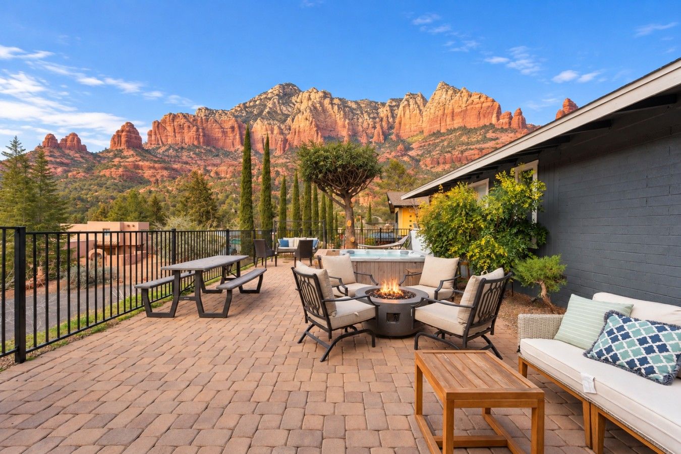 An outdoor patio with a fire pit, seating, and a view of red rock formations.