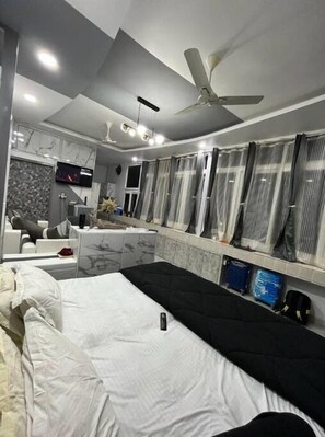 Relax in a serene space with a comfortable bed, flat-screen TV, and ceiling fan.