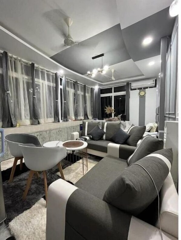 Relax in this stylish living room with a large sofa, coffee table, and armchairs.