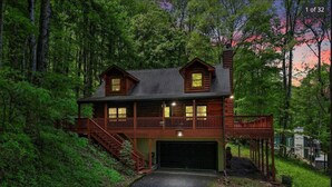 A two-story log cabin with a covered front porch and a garage. - Smokey Mountain Retreat (Waynesville)