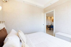 Une chambre à coucher avec un lit, des oreillers, un bureau et une chaise au fond.