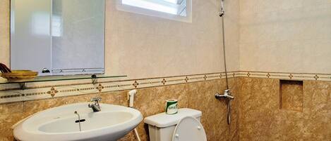 Un baño con lavamanos, inodoro y ducha.