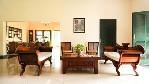 A traditional room with wooden furniture, a clock, and a framed picture on the wall. - Margo Utomo Eco Resort (Kalibaru)