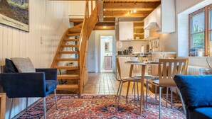 A cozy interior with a wooden staircase, a dining area, and a kitchen. - Holiday Apartment 'Alte Polsterei' with Private Terrace, Shared Garden and Wi-Fi (Nienstädt)