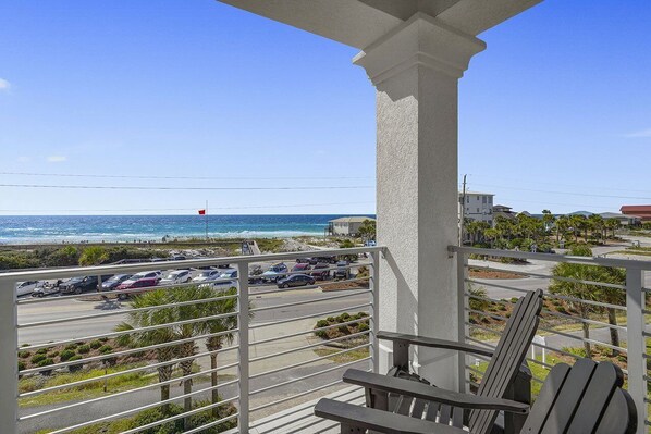 A balcony with a view of the ocean and a parking lot. - Beachfront Babes - Near the Beach with Ocean Views & Private Pool Area (Santa Rosa Beach)