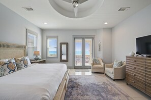 A bedroom with a large bed, a television, a dresser, and a chair. - Beachfront Babes - Near the Beach with Ocean Views & Private Pool Area (Santa Rosa Beach)