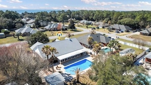 A residential area with houses, a swimming pool, and a view of the ocean.