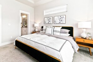 A bedroom with a bed, bedside tables, a nightstand, a lamp, a mirror, and artwork on the wall. - Top Rated • Spotless & Spacious • Near Top Dining, Shopping & Entertainment (Meridian)