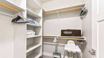 Un vestidor con estantes, una sillita de bebé Graco y un taburete.