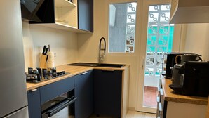 Une cuisine de taille réduite, équipée d’un évier, d’une cuisinière et d’un four.