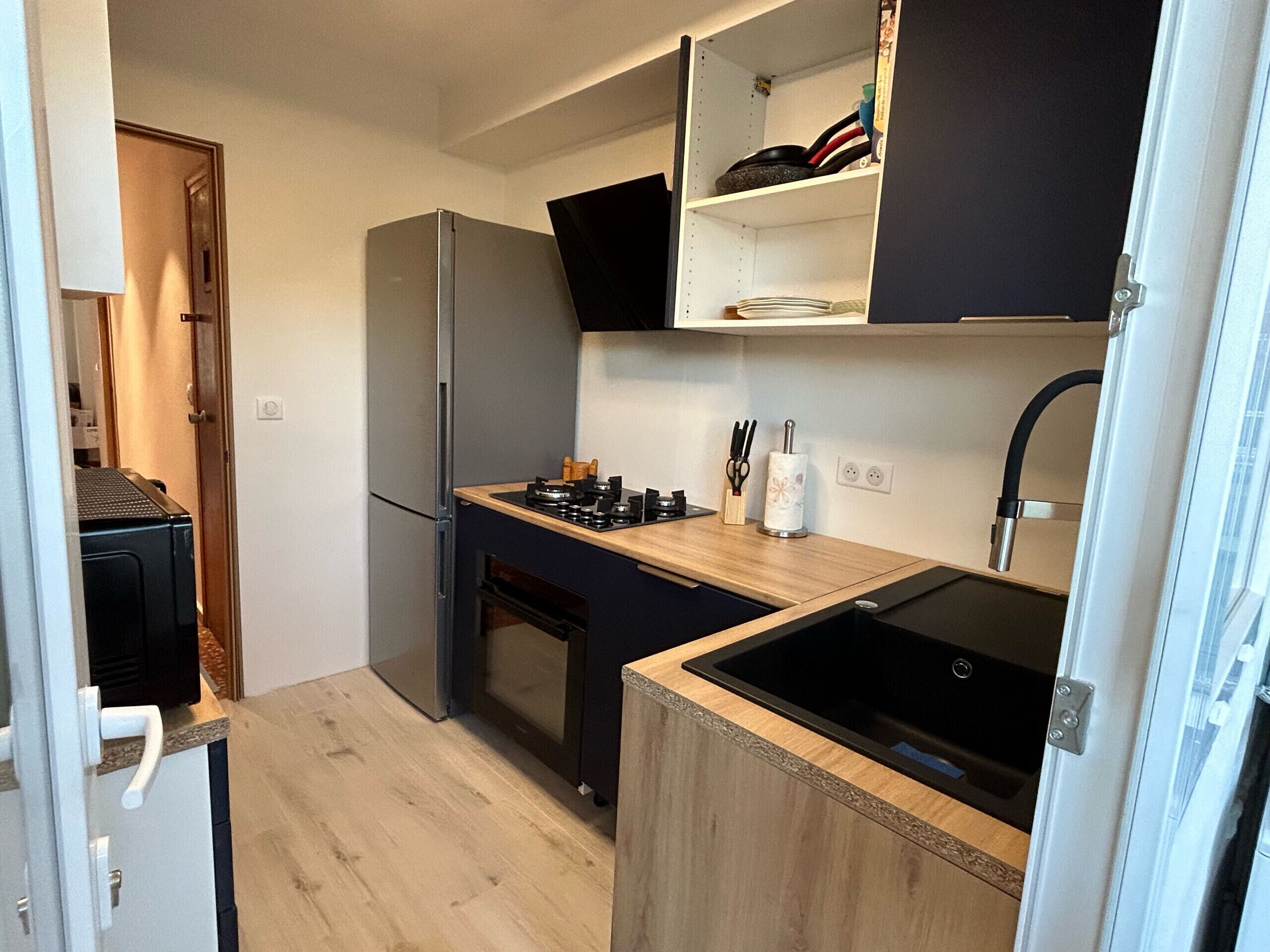 A compact kitchen with a built-in stove, a refrigerator, and a sink.