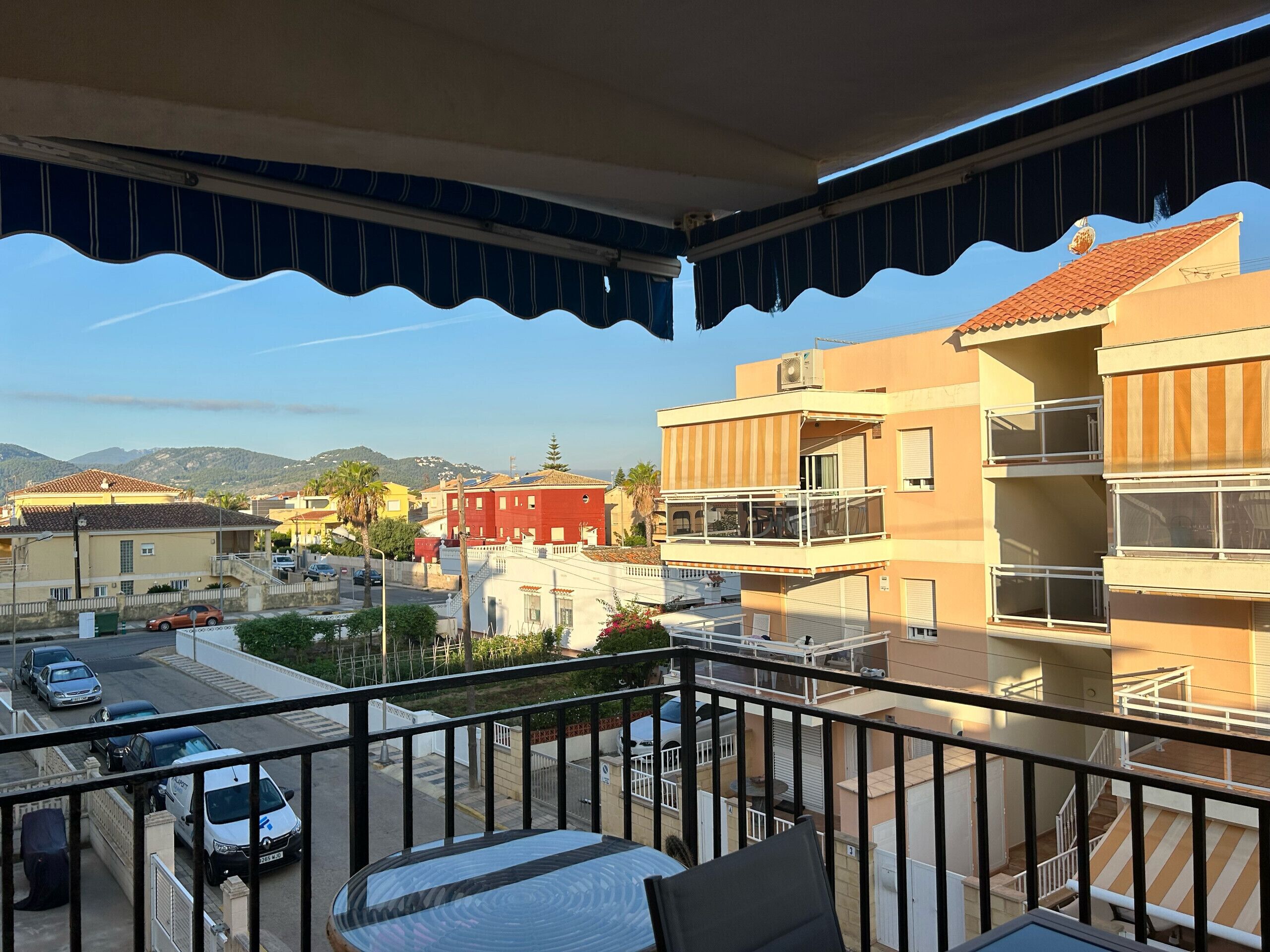 Ein Balkon mit Blick auf ein Wohngebiet, einschließlich Gebäude und parkenden Autos.
