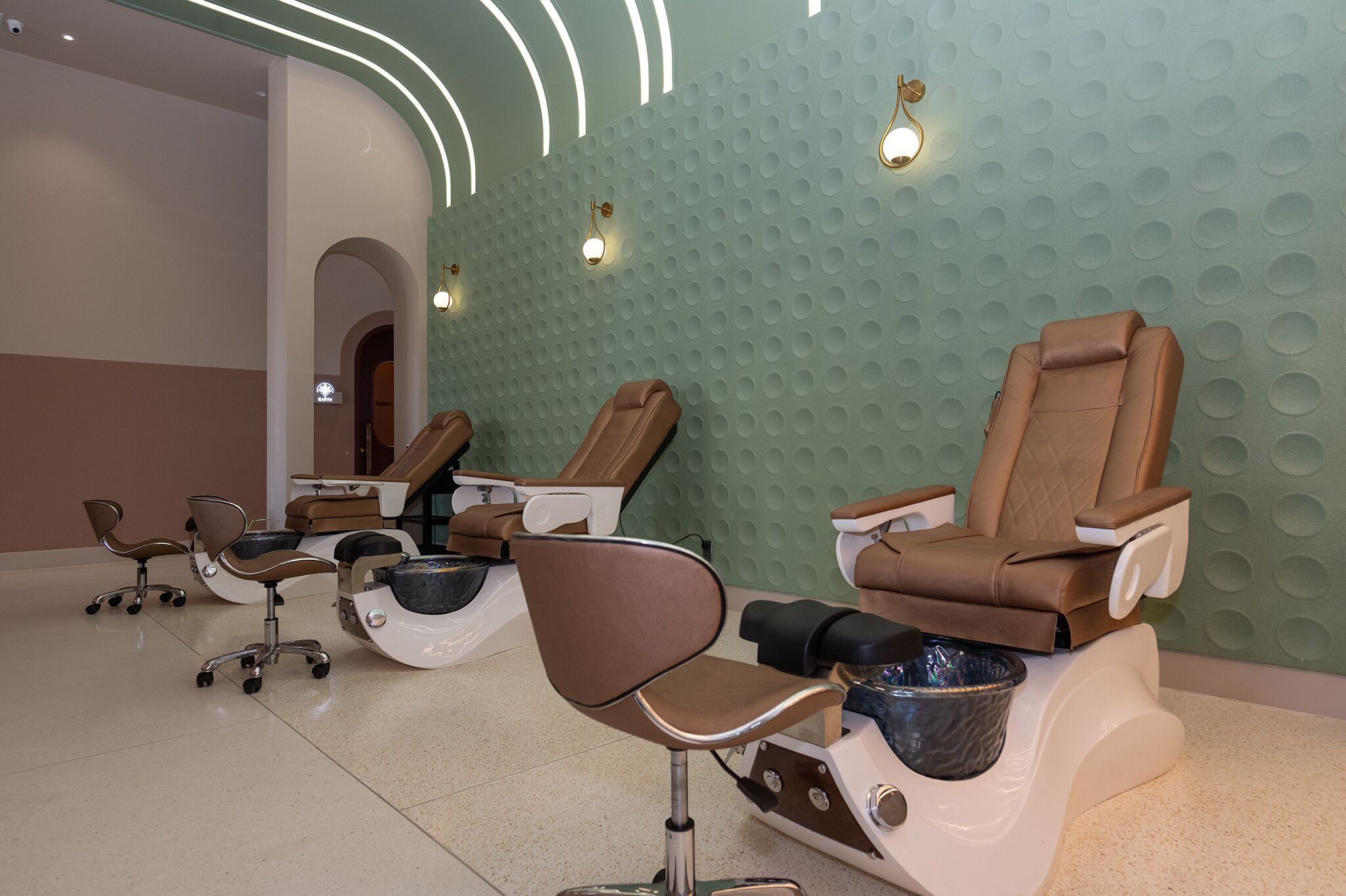 Un salon équipé de plusieurs fauteuils de massage et d’un espace d’accueil.