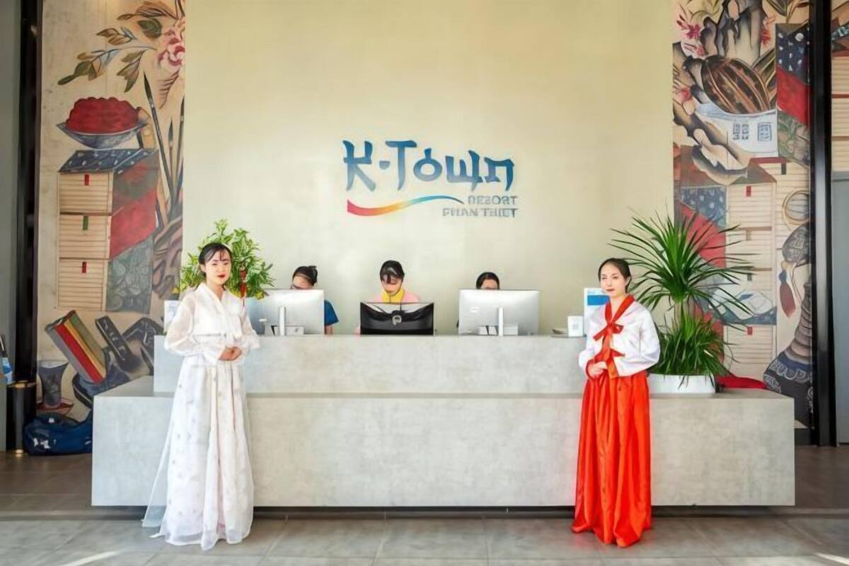A reception desk with a sign reading 'H-Town Resort & Spa' and a mural on the wall.
