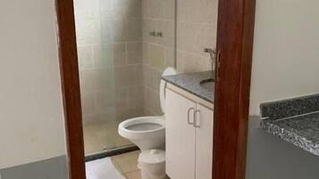 Un baño con ducha, inodoro y lavamanos.