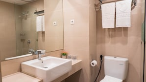 Ein modernes Badezimmer mit Waschbecken, Spiegel, Toilette und Dusche.