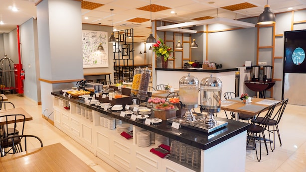 Ein Buffetbereich mit verschiedenen Speiseauslagen, darunter eine Kaffeemaschine und eine Obstausstellung.