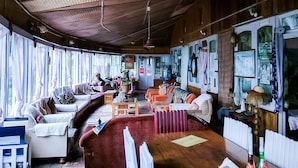 A cozy room with wooden walls, a large window, and a sofa.