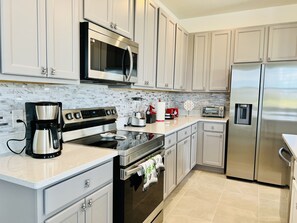 Enjoy cooking in this well-equipped kitchen with stainless steel appliances, light cabinetry, and a convenient coffee maker and toaster.
